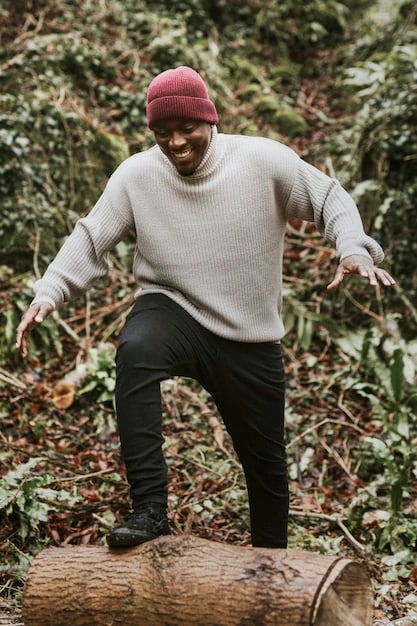 Idris Okoro, photographed in a dynamic pose on set, wearing a stylish yet rugged outfit. The background features the bustling activity of a film set, complete with cameras and crew members, highlighting the energy and excitement of the production.