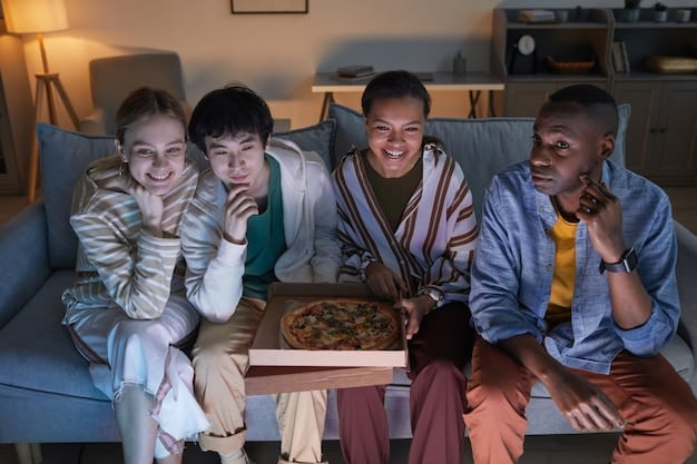 A diverse group of friends comfortably sitting on a sofa, laughing and interacting while watching a TV show together, with pizza boxes and soft drinks scattered around.