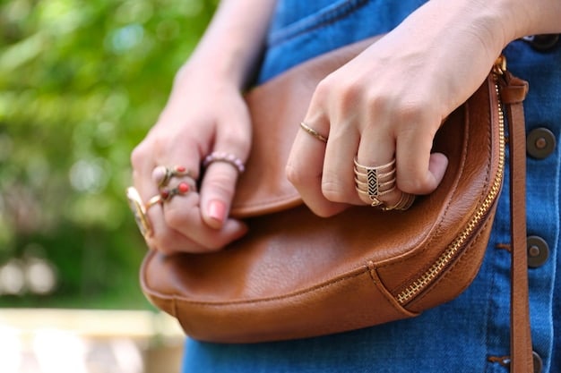 A stylish person accessorizing with a minimalist, structured leather handbag and delicate gold jewelry, complementing a neutral-toned outfit, illustrating the 