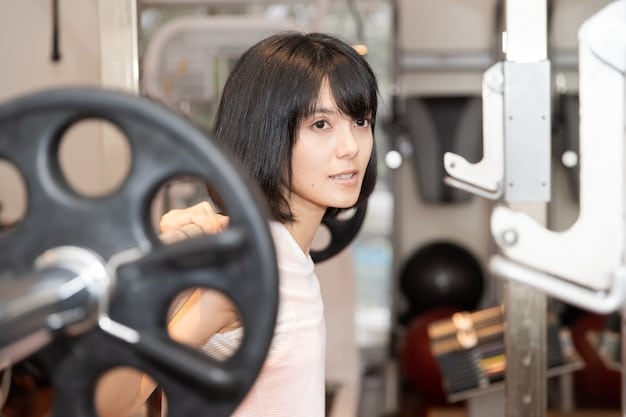 Kim Bok-joo lifting weights in a gym, with a determined expression, surrounded by weightlifting equipment.