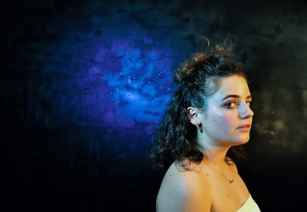 A close-up shot of Principal Weems' face, illuminated by a faint, otherworldly glow, her expression contemplative and slightly ethereal, hinting at a mystical transformation or return.