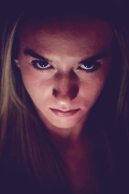 A close-up of a young woman's face, her eyes wide with a mixture of fear and determination, suggesting the psychological strain and moral compromises faced by the survivors in a desperate situation.