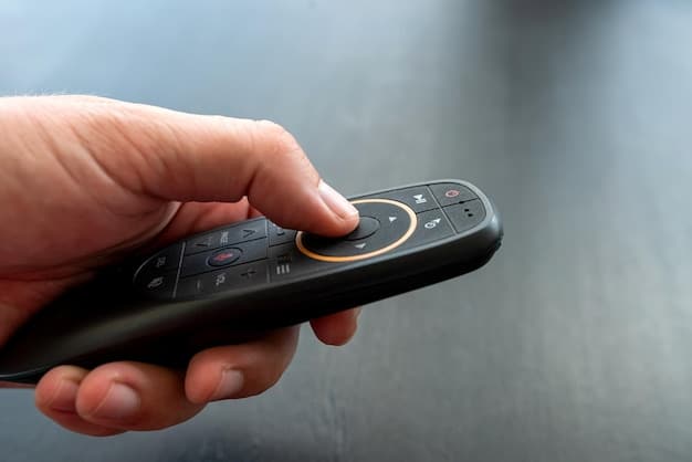 A close-up shot of a TV remote control, with fingers hovering over the play button, symbolizing the act of starting another episode of a binge-worthy series. The background is blurred, showing a living room with soft lighting.