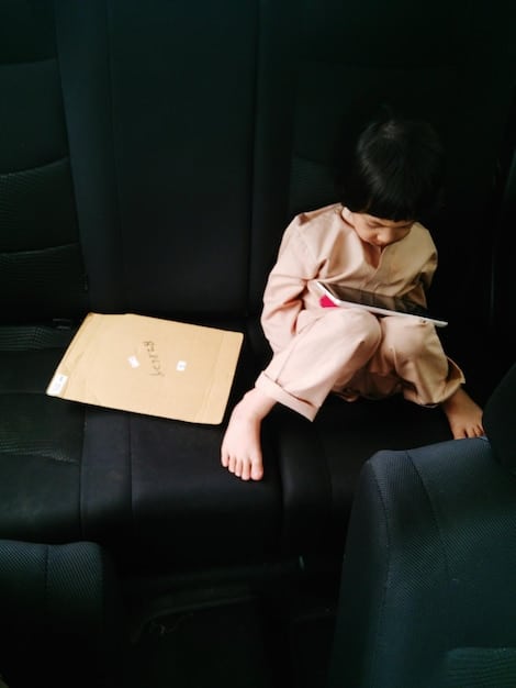 A K-drama actress sleeping in a chair between takes on set. She looks exhausted, with dark circles under her eyes. The background shows crew members working busily, highlighting the hectic pace of K-drama production. The scene captures the physical toll and exhaustion faced by actors due to demanding schedules.
